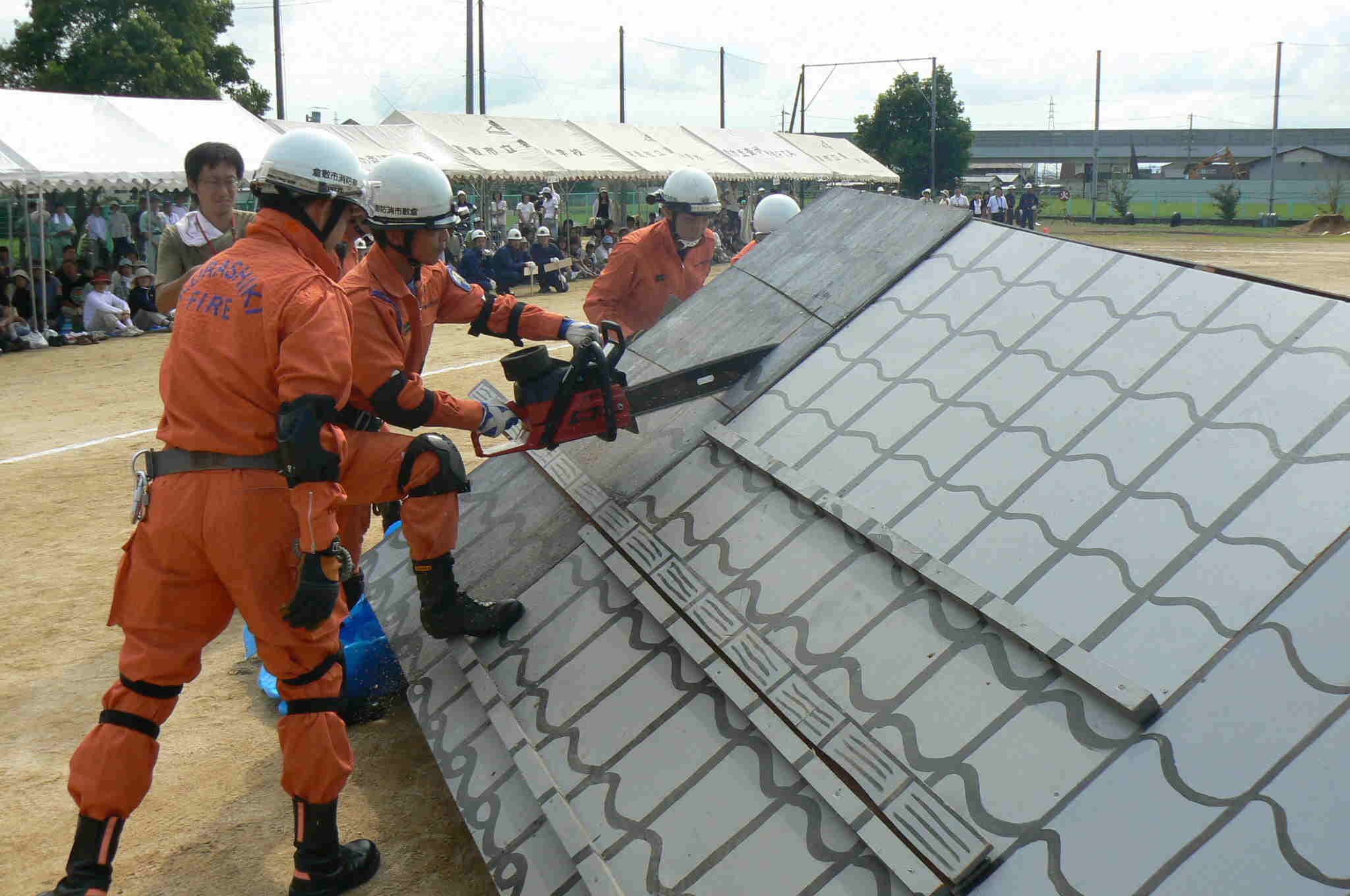 防災訓練　救助隊が屋根を切断している写真