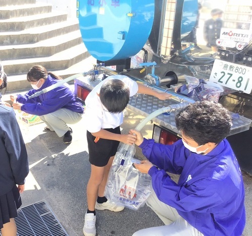 写真：給水車から給水パックに注水する様子