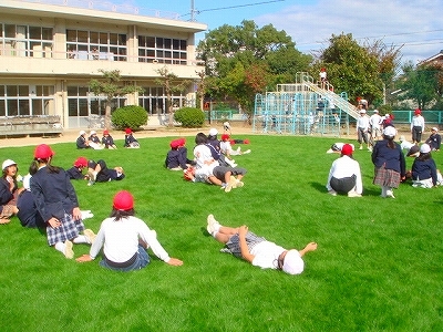 写真：芝生で寝転ぶ児童／倉敷東小学校