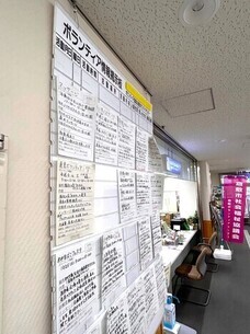 ボランティアセンターに設置されている掲示板の写真。ホワイトボードに何枚もボランティアを募集する紙が貼りつけられている。