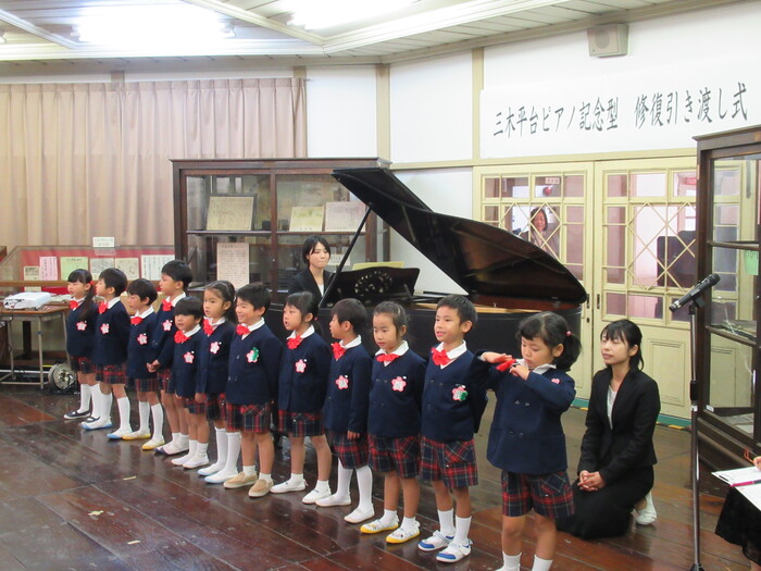 修復したグランドピアノで合唱する園児
