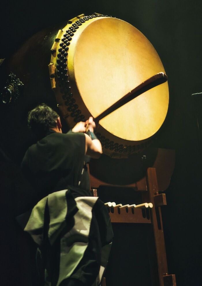 日本の太鼓で太鼓を演奏する男性の画像
